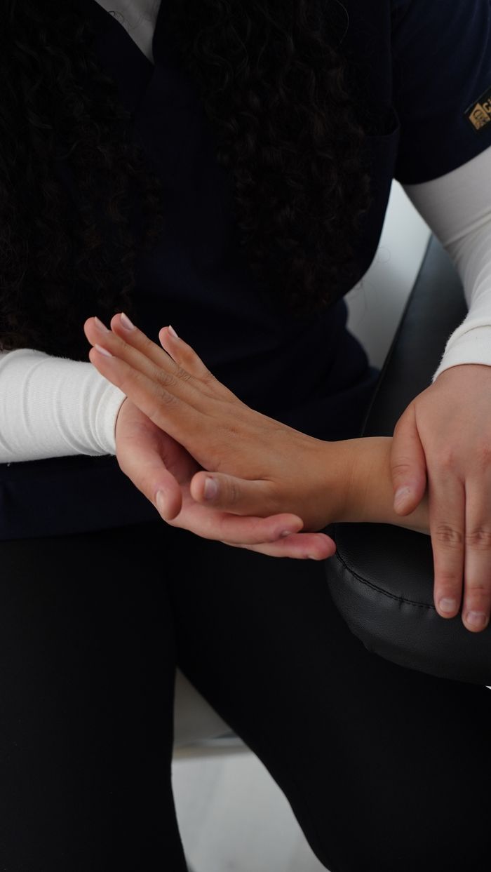 A professional therapist performing hand massage to relieve tension and improve wellness.